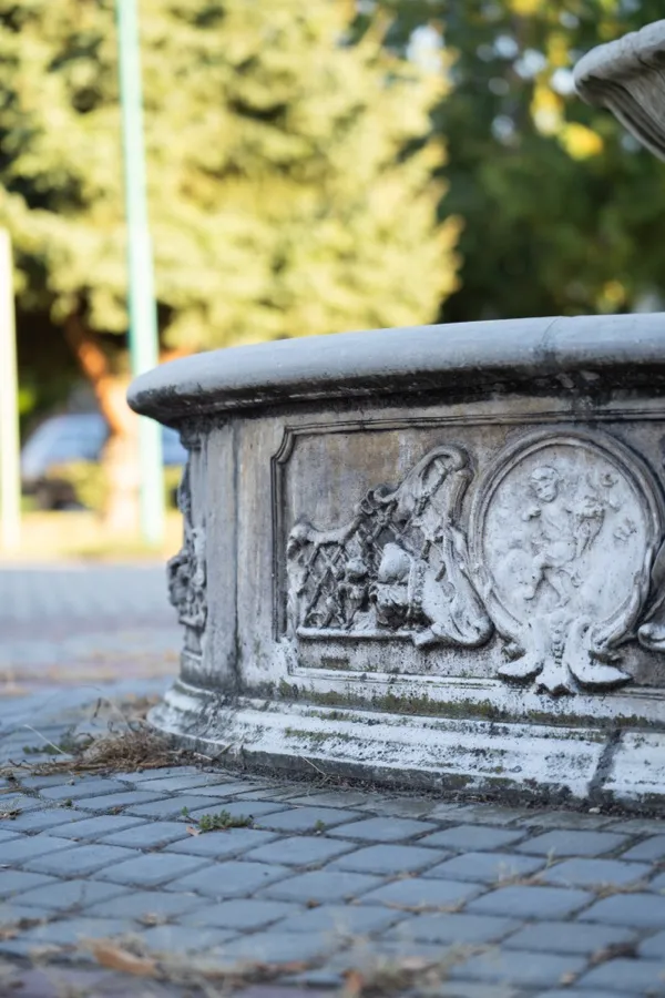 Kamenná obruba fontány s reliéfom